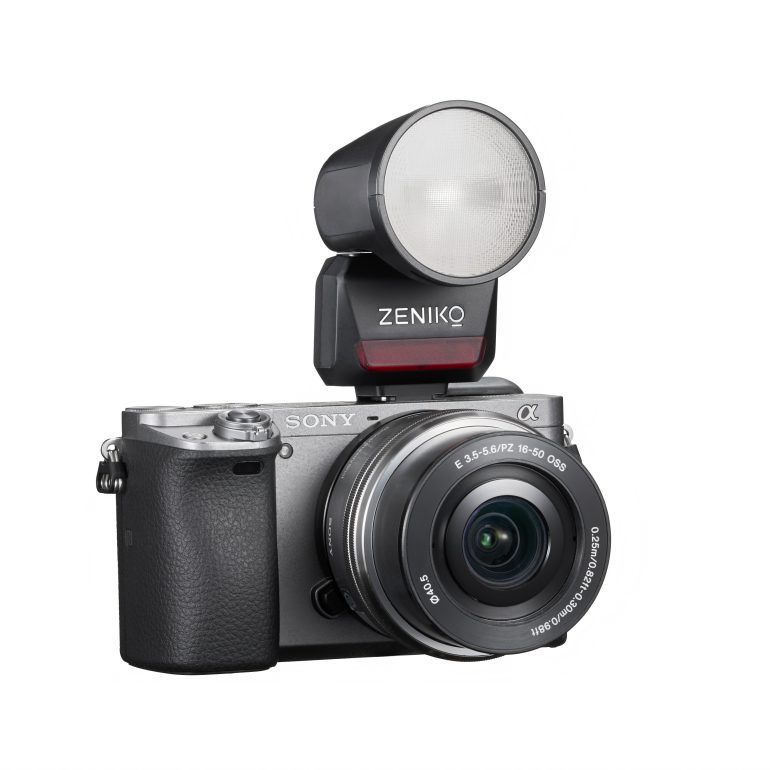 A Sony digital camera with a Zeniko external flash attached to the top.