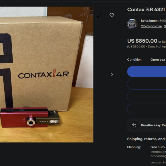 Red Contax i4R camera placed in front of its brown box, displayed on an online selling page.