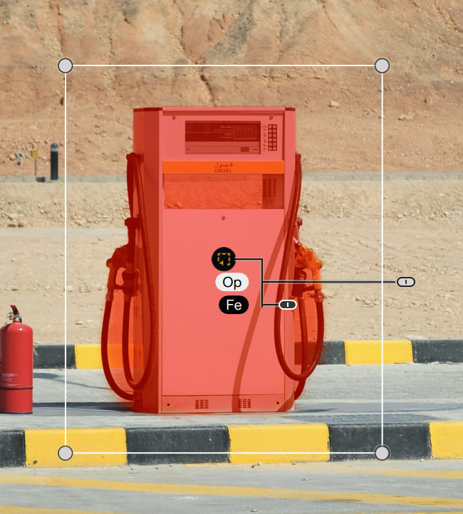 A red gas pump with diagrams on it, on a paved area near a dirt embankment.
