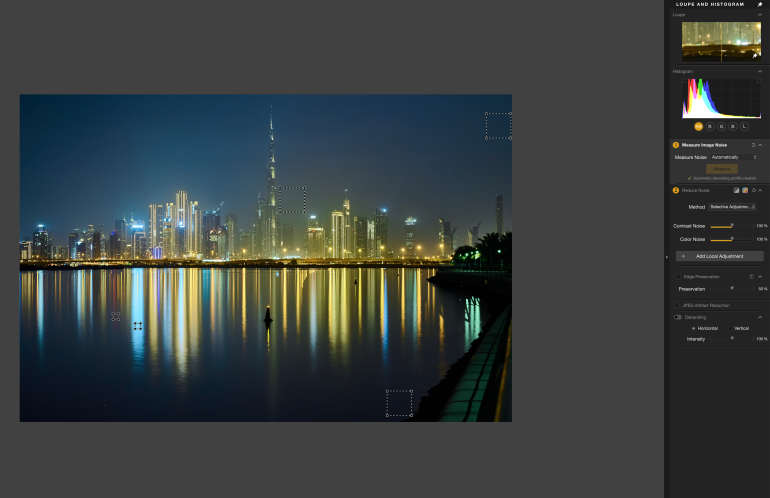 Night cityscape with skyscrapers and colorful reflections on calm water, editing tools visible on the right.
