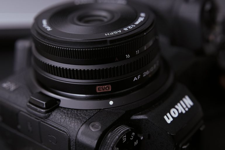 Close-up of a Nikon camera lens showing aperture settings and the word EVO on the lens ring.