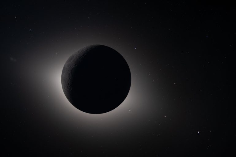 A dark planet or moon is silhouetted against space, with a glowing halo and stars in the background.