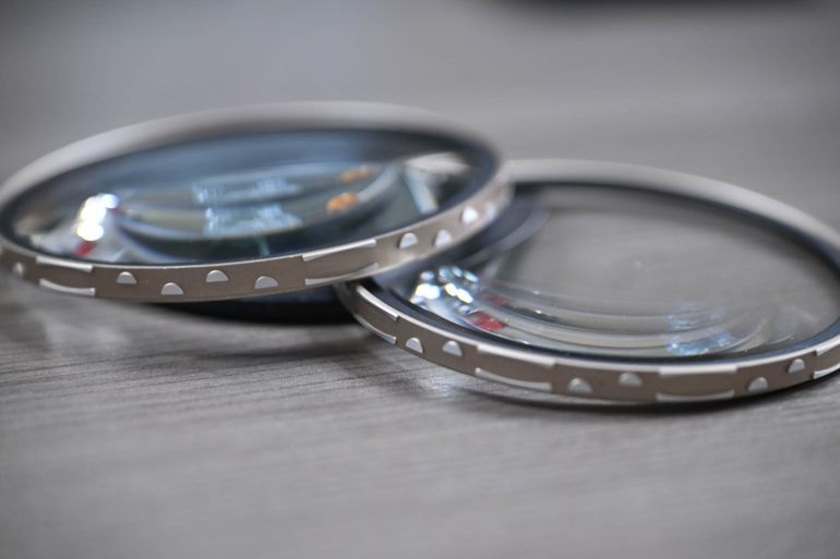 Two close-up camera lens filters with metallic edges on a gray surface.