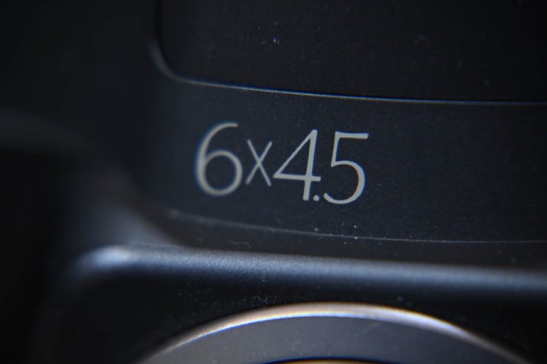 Close-up of 6x4.5 text printed in white on a dark surface, possibly a camera or lens.